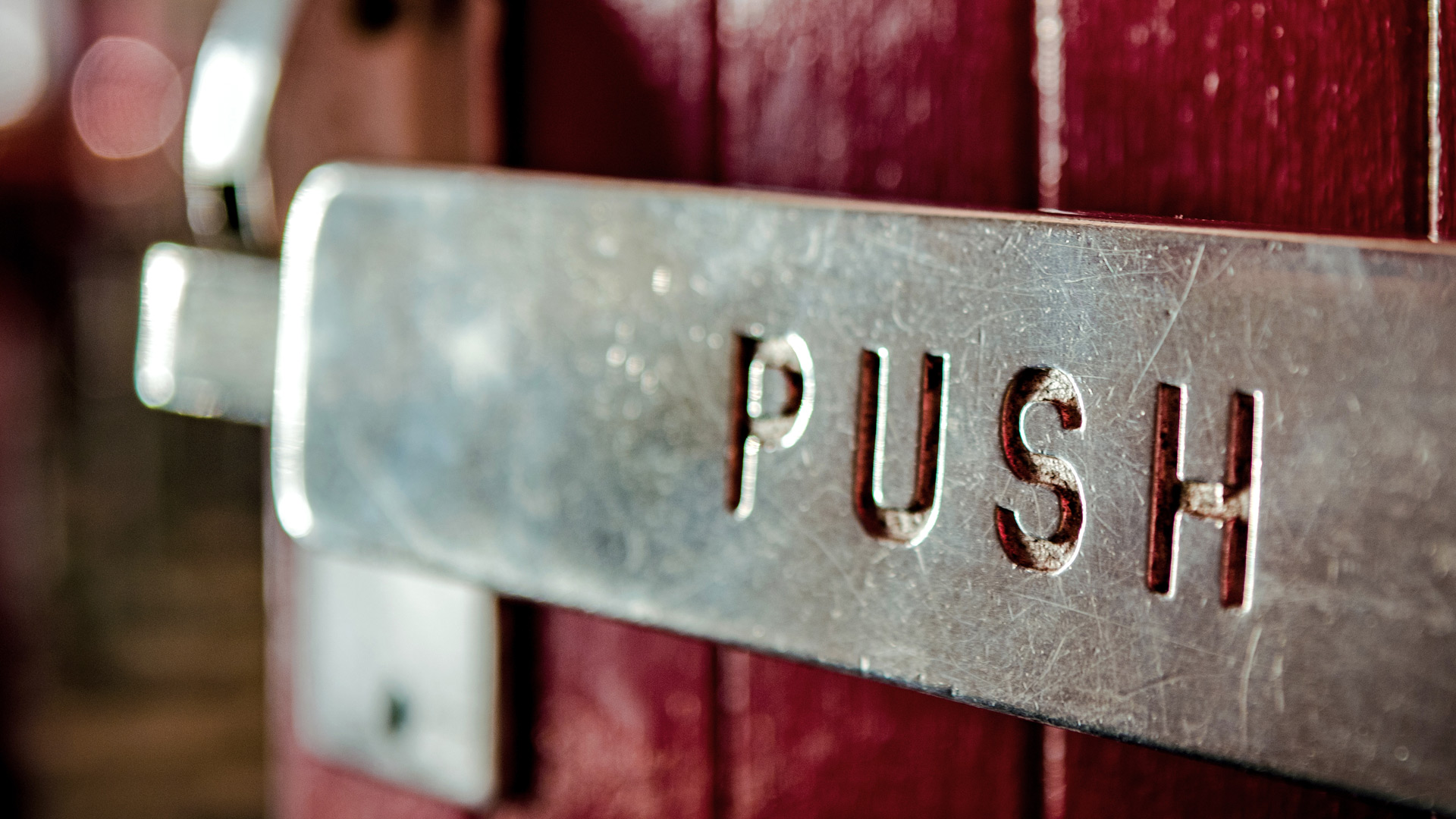 Metal door lever with the word push (Tim Mossholder unsplash.com)