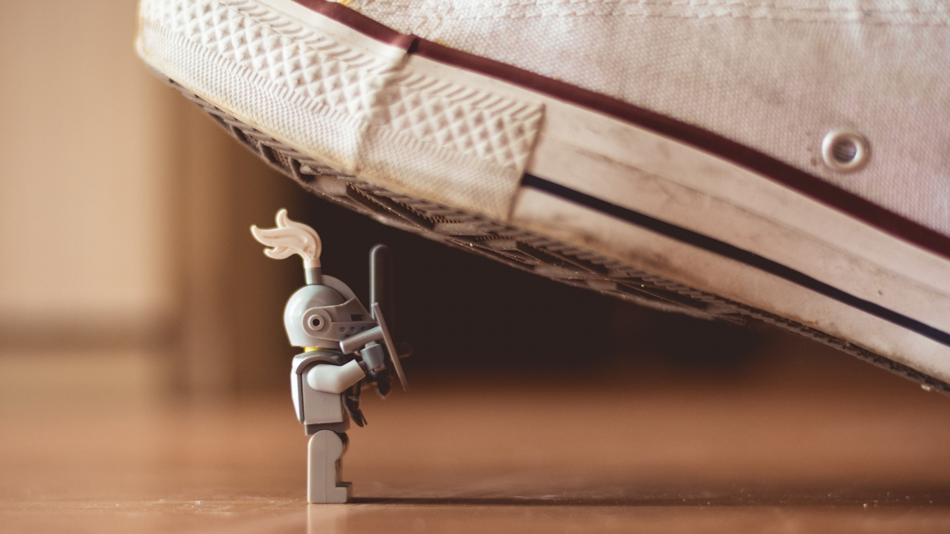 Lego knight with sword stand firm even though seemingly about to get squashed by a much larger foe (James Pond unsplash.com)