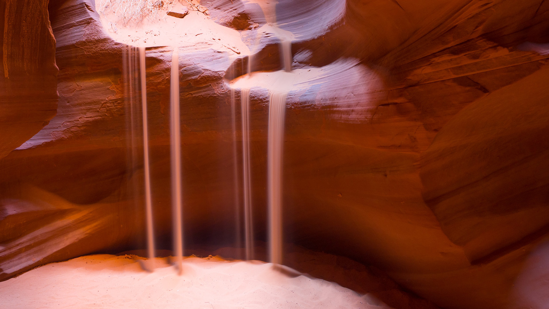 Streams of sand pouring into a cave (George Fitzmaurice unsplash.com)